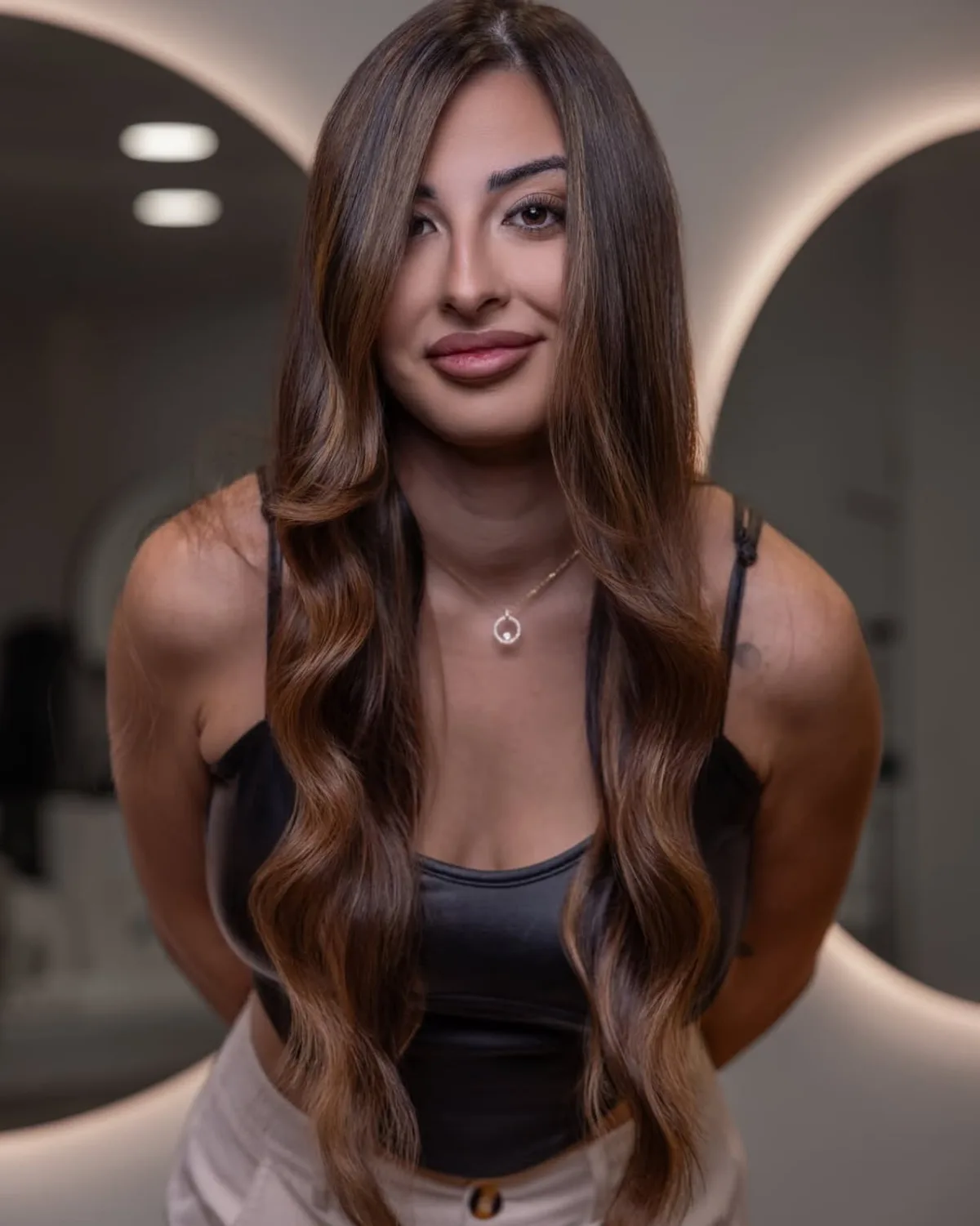 Clienta con melena morena iluminada y ondas suaves realizadas en el salón